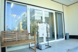 鴻巣のアイデザイン ツツ.のガラス扉とベンチのある店舗入口